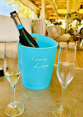 a bottle of wine in a bucket next to two glasses at Polarstar Apartment in Sveti Vlas