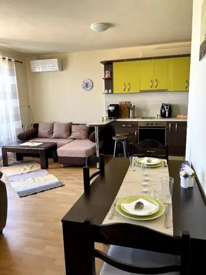 a kitchen and living room with a table and a couch at Морска Идилия in Burgas City