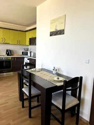 a kitchen with a black table and chairs at Морска Идилия in Burgas City