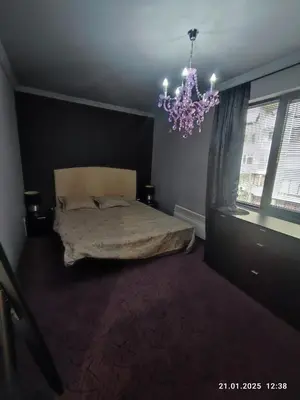 a bedroom with a bed and a chandelier at Central View Burgas in Burgas City