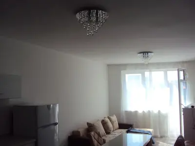 a living room with a couch and a chandelier at Apartment Alyosha in Burgas City