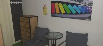a room with a chair and a table and a painting at AT Home in Burgas City