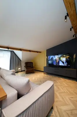a living room with two couches and a large screen tv at Tsaribrod Design Apartments in Varna City