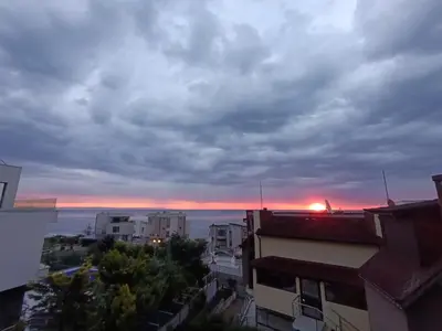 a view of the sunset from a city with buildings at Via Sunride 1 - Maisonette Apartment by the sea in Sozopol