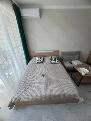 a bed sitting in a room with a window at Sol e Mar Private Apartment in Sunny Beach