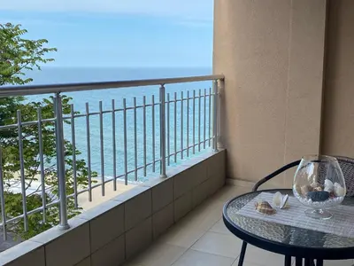 a balcony with a table and a view of the ocean at Зора-Обзор in Obzor