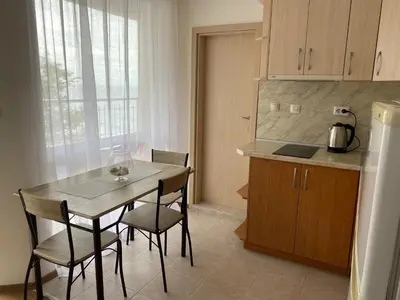 a kitchen with a table and chairs and a counter at Зора-Обзор in Obzor