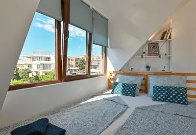 two beds in a room with two windows at Via Sunride 2 - Maisonette Apartment by the sea in Sozopol