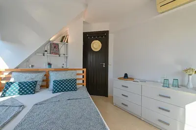 a bedroom with a bed with blue pillows and a closet at Via Sunride 2 - Maisonette Apartment by the sea in Sozopol
