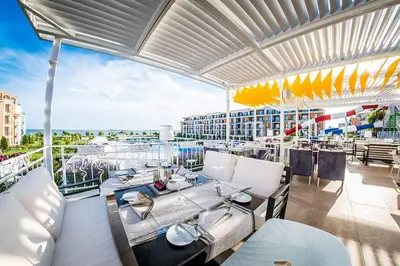 a patio with a table and chairs on a balcony at Апартамент в отеле Premier Fort Beach in Sveti Vlas
