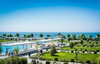 a resort with a pool and the ocean in the background at Апартамент в отеле Premier Fort Beach in Sveti Vlas