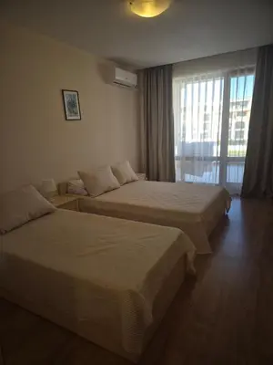 two beds in a hotel room with a window at Апартамент в отеле Premier Fort Beach in Sveti Vlas