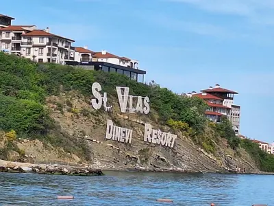 a hill with graffiti on it next to the water at Arena I by the Sea in Sveti Vlas