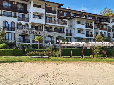 an apartment building with a beach in front of it at Arena I by the Sea in Sveti Vlas