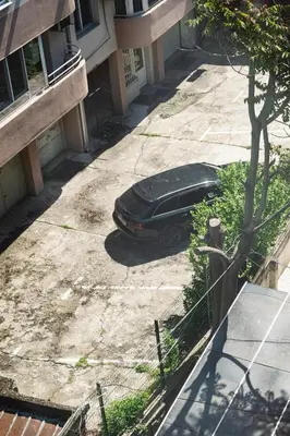 a black car parked on the sidewalk next to a building at Апартамент Морски уют in Burgas City
