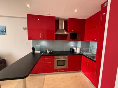 a red kitchen with a black counter top at Diamond by the Sea in Sveti Vlas