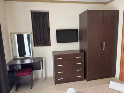 a bedroom with a desk and a dresser with a television at Diamond by the Sea in Sveti Vlas