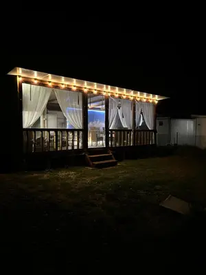 a marquee lit up at night with lights on it at Каравана Кътче От Рая in Tsarevo