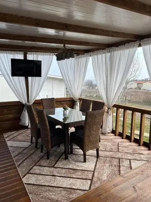 a patio with a table and chairs on a deck at Каравана Кътче От Рая in Tsarevo