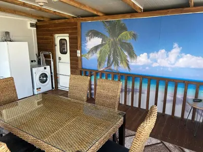 a dining room with a table and chairs on a balcony at Каравана Кътче От Рая in Tsarevo