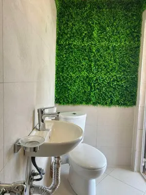 a bathroom with a toilet and a green wall at Каравана Кътче От Рая in Tsarevo
