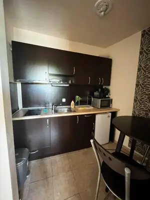 a small kitchen with a sink and a table at Paradise apartment Sozopol in Sozopol