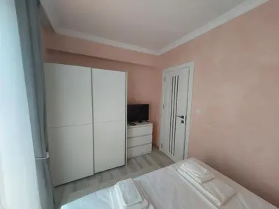 a bedroom with a white cabinet and a bed at Sofi's Harmony in Burgas City
