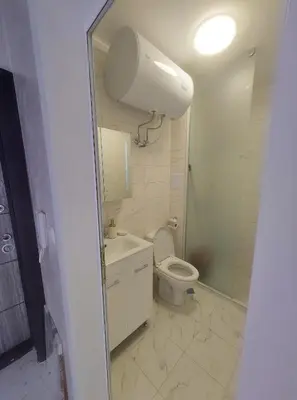 a bathroom with a toilet and a sink and a mirror at Sofi's Harmony in Burgas City