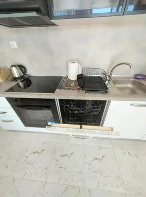 a kitchen counter with a sink and a dish drying rack at Sofi's Harmony in Burgas City