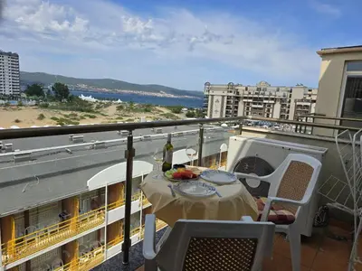a balcony with a table and chairs on a ship at Sea View Dune Apartment in Sunny Beach