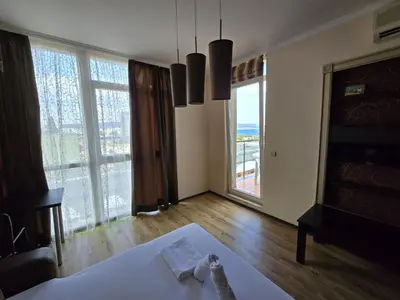 a living room with a table and large windows at Sea View Dune Apartment in Sunny Beach