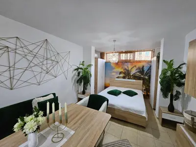 a bedroom with a bed and a table with a dining room at Tropical Chic for Two, Basement Studio Escape by Flat Mаnager in Ravda