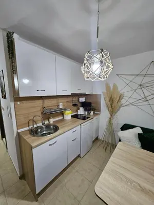 a kitchen with white cabinets and a sink at Tropical Chic for Two, Basement Studio Escape by Flat Mаnager in Ravda