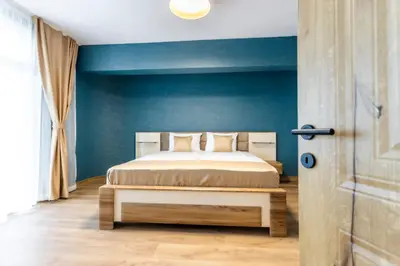 a bedroom with a bed and a blue wall at Hotel Laguna SPA in Sveti Vlas