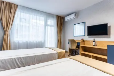 a hotel room with two beds and a television at Hotel Laguna SPA in Sveti Vlas