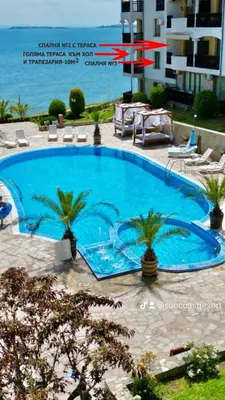 a large swimming pool with palm trees next to a building at Под наем 4-стаен Апартамент с Изумителна фронтална гледка море, Sun Coast resort Свети Влас in Sveti Vlas