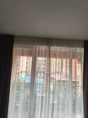 a window with curtains in front of a building at Apartment Sunny View Central in Sunny Beach