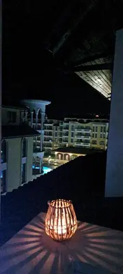 a lamp sitting on a table with a view of a city at Royal sun in Sunny Beach