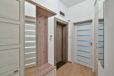 a walk in closet with white walls and wooden cabinets at City center 2BR next to Sea in Varna City