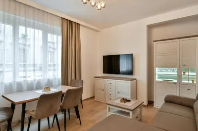 a living room with a table and a tv at City center 2BR next to Sea in Varna City