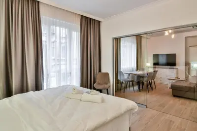 a bedroom with a large bed and a dining room at City center 2BR next to Sea in Varna City