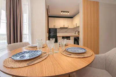 a dining room table with plates and glasses on it at Marina and Panorama Deluxe Apartments in Burgas City