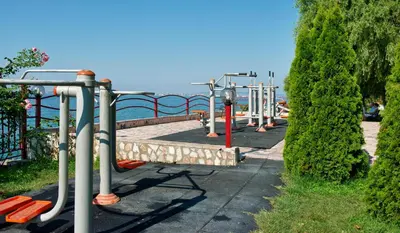 a row of exercise equipment in a park near the water at Marina and Panorama Deluxe Apartments in Burgas City