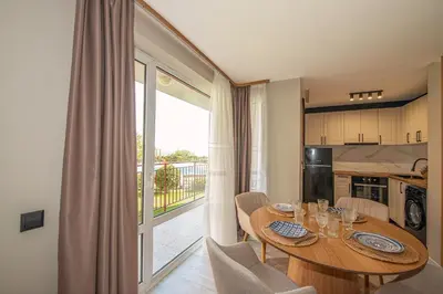 a kitchen and dining room with a table and a window at Marina and Panorama Deluxe Apartments in Burgas City