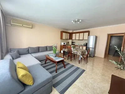 a living room with a blue couch and a table at Sofronii Pomorie Residence in Pomorie