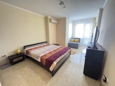 a bedroom with a bed and a flat screen tv at Sofronii Pomorie Residence in Pomorie