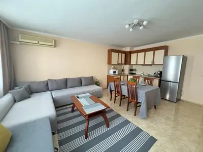 a living room with a couch and a table and a kitchen at Sofronii Pomorie Residence in Pomorie