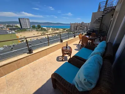 a balcony with couches and a view of a beach at Sea View Luxury Penthouse in Sunny Beach