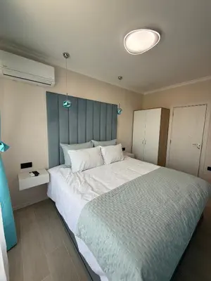 a bedroom with a large bed with a blue headboard at Sea Sun in Burgas City