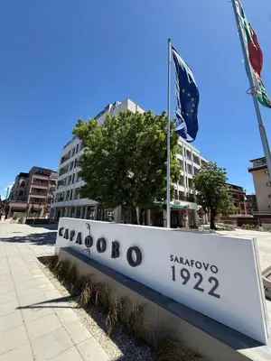 a sign in front of a building with a flag at Sea Sun in Burgas City